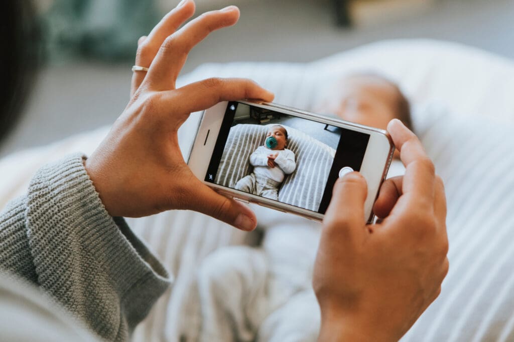 Mother snapping a photo of her newborn for her Modern Baby Book.
